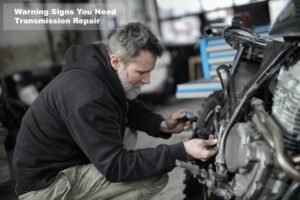 Expert checking transmission for signs of it going bad
